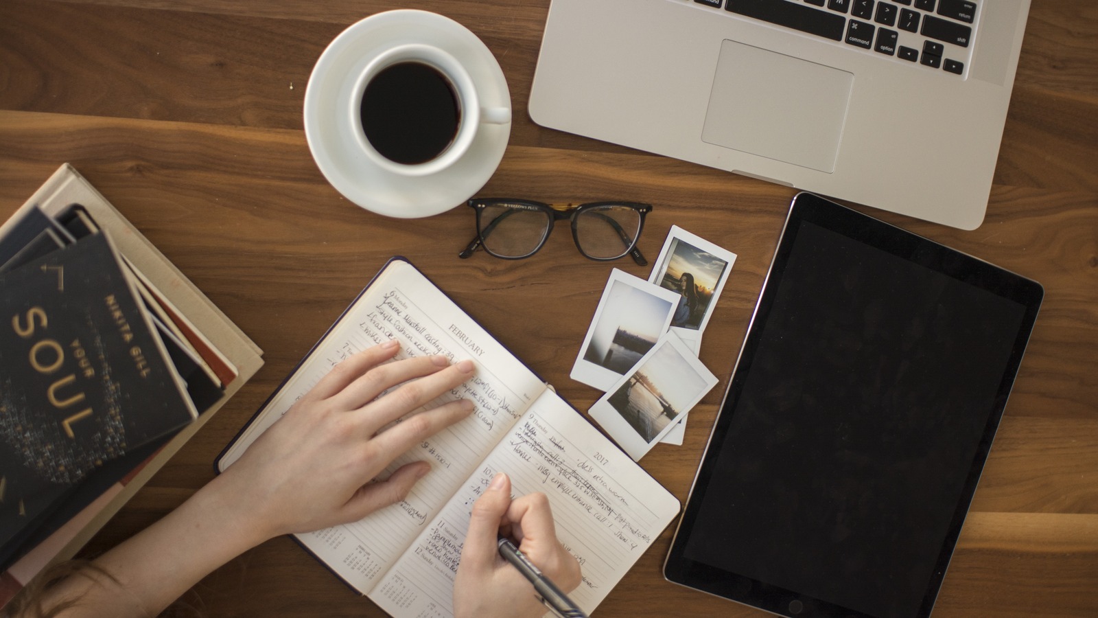 A laptop, phone, coffee and notebook on a quiet desk
